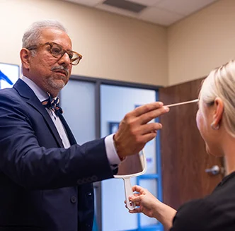 Dr. Siddiqui using a long q-tip to touch patients face - Skin & Hair in Thiensville, WI